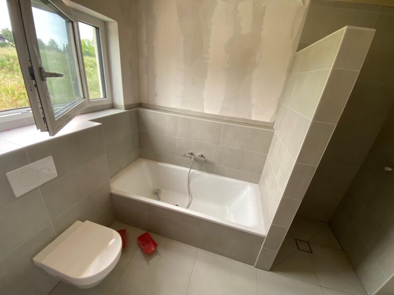 Badezimmer mit Großformatfliesen in Marmoroptik und Badewanne