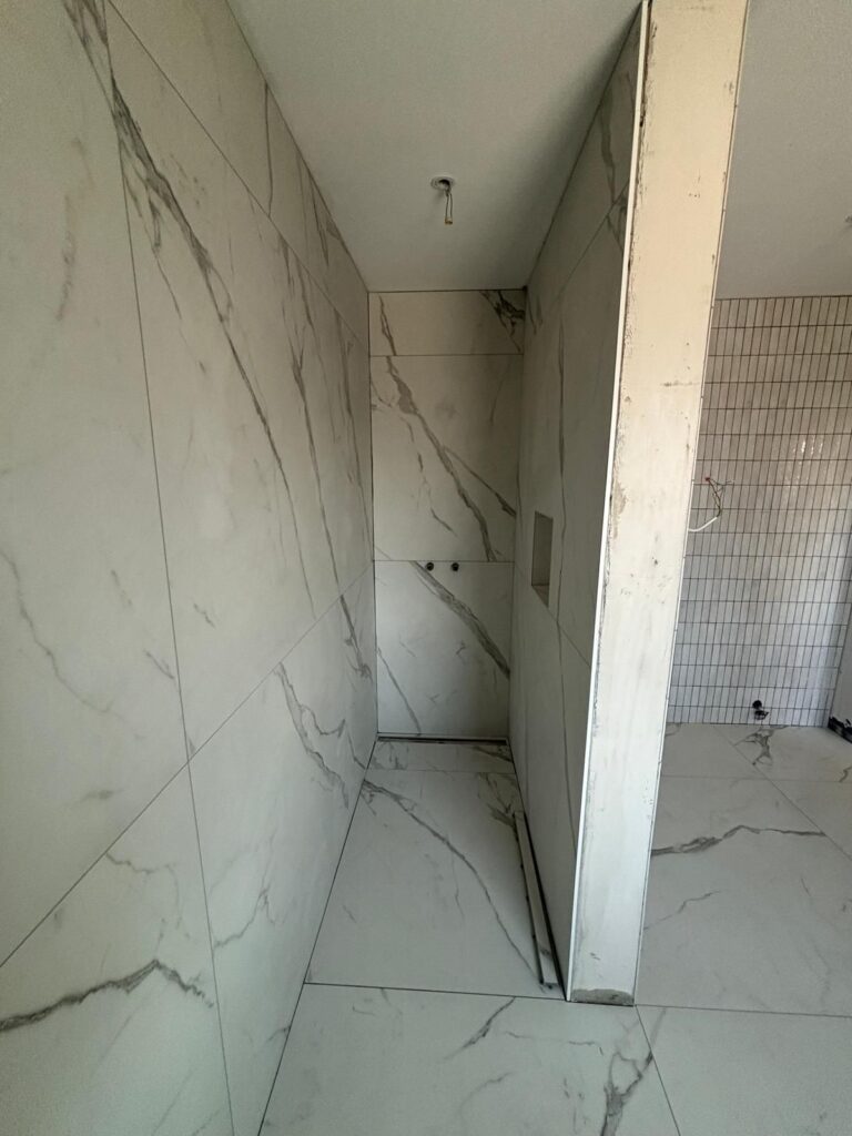 Dusche mit Großformatfliesen in Marmoroptik
