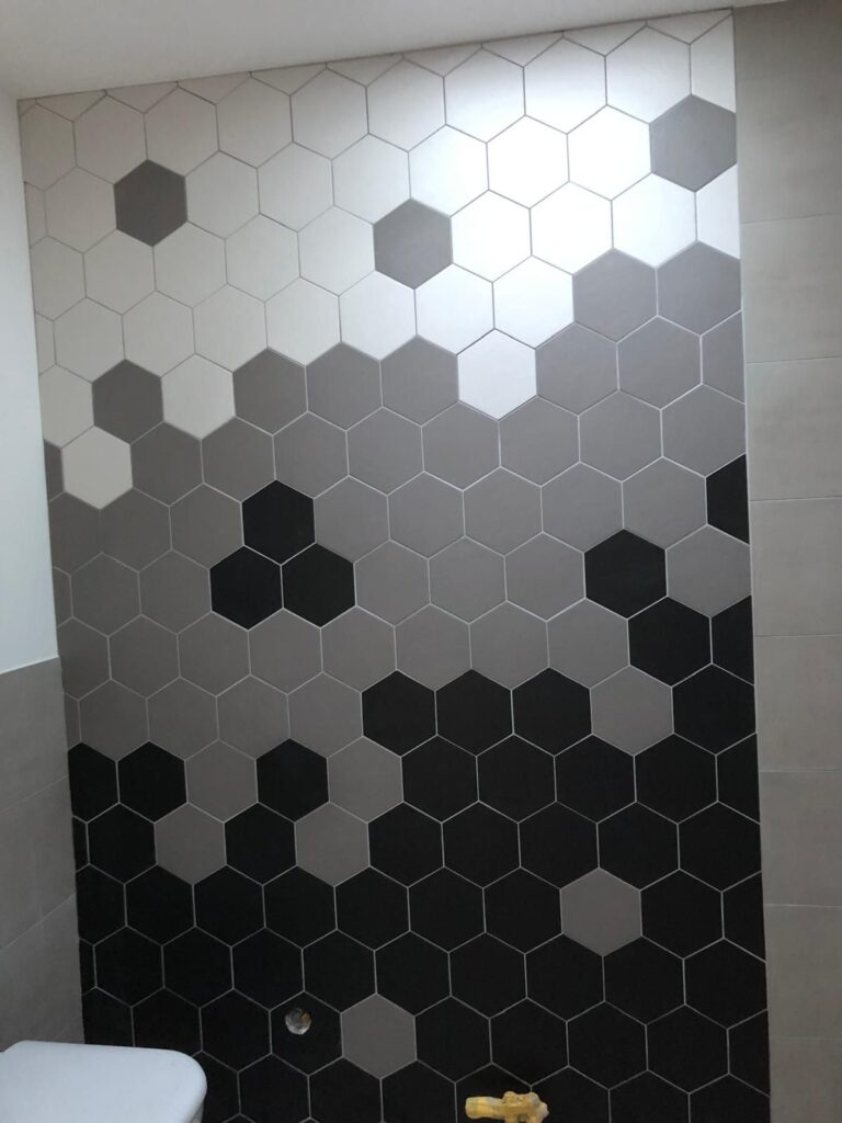 Wand mit Hexagon-Fliesen in Schwarz, Grau und Weiß im Farbverlauf